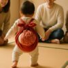 赤ちゃんが一升餅を背負って立とうとする